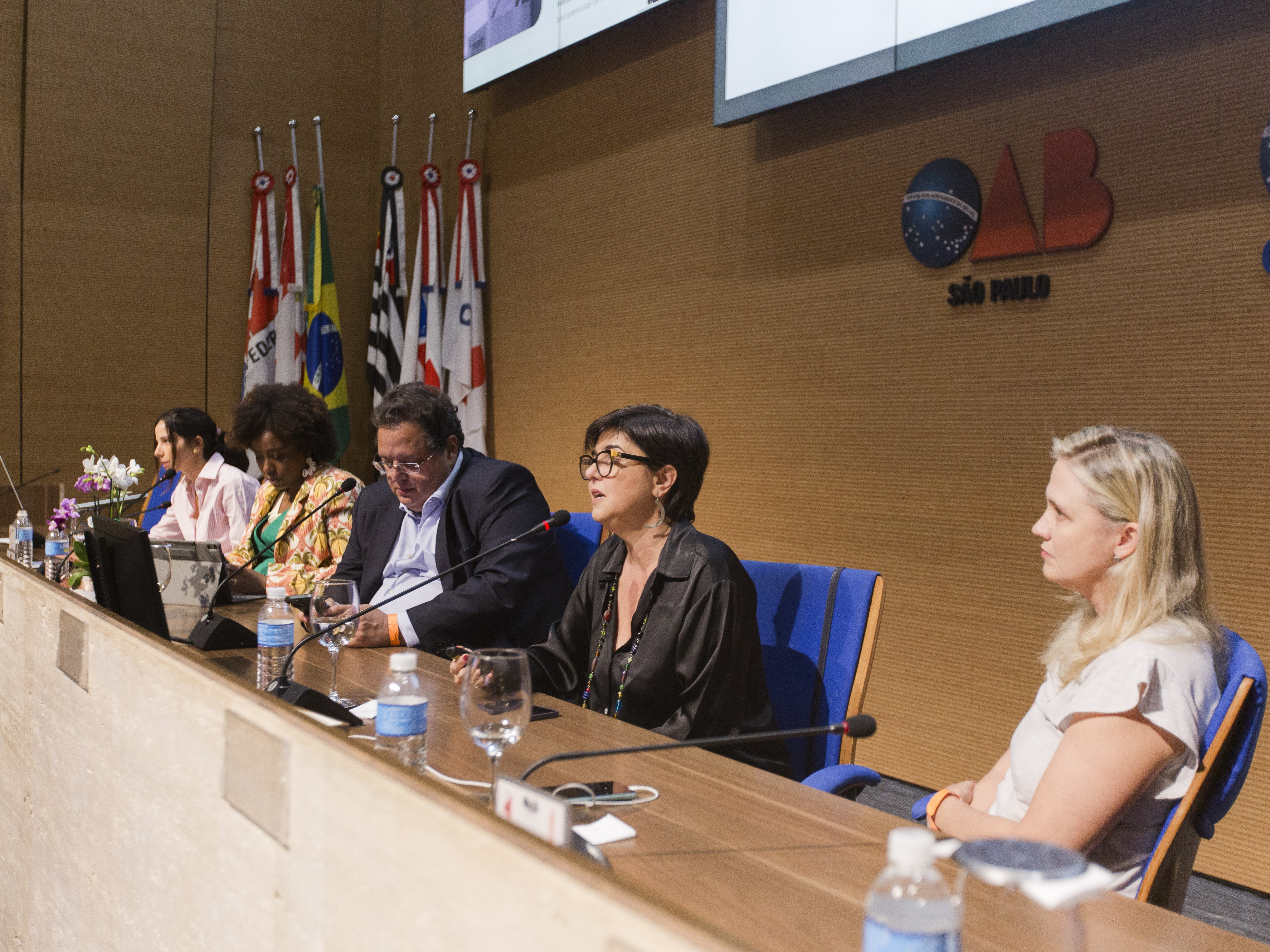 Um grupo de pessoas sentadas em uma mesa discutindo e interagindo.