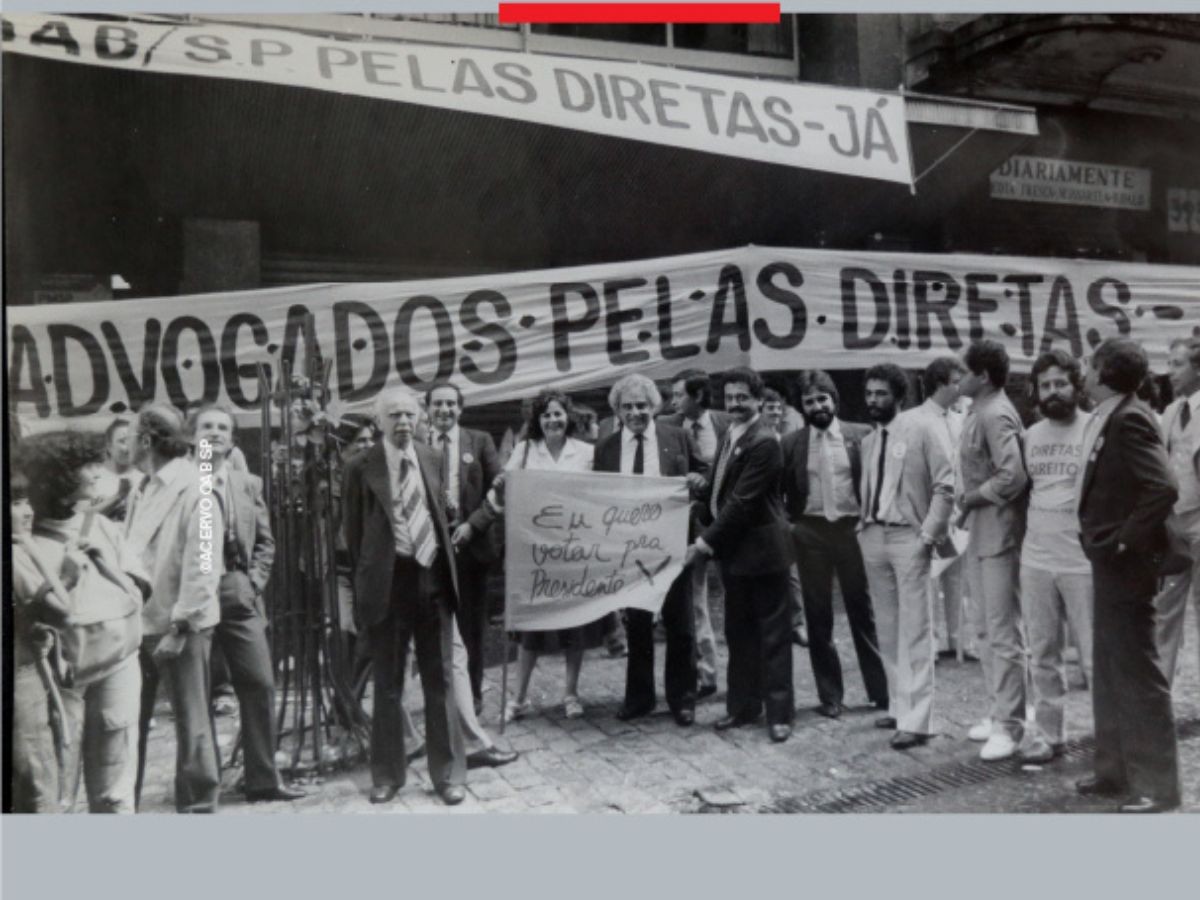 Foto antiga com advogados na porta da OAB com faixas pedindo pelas Diretas Já