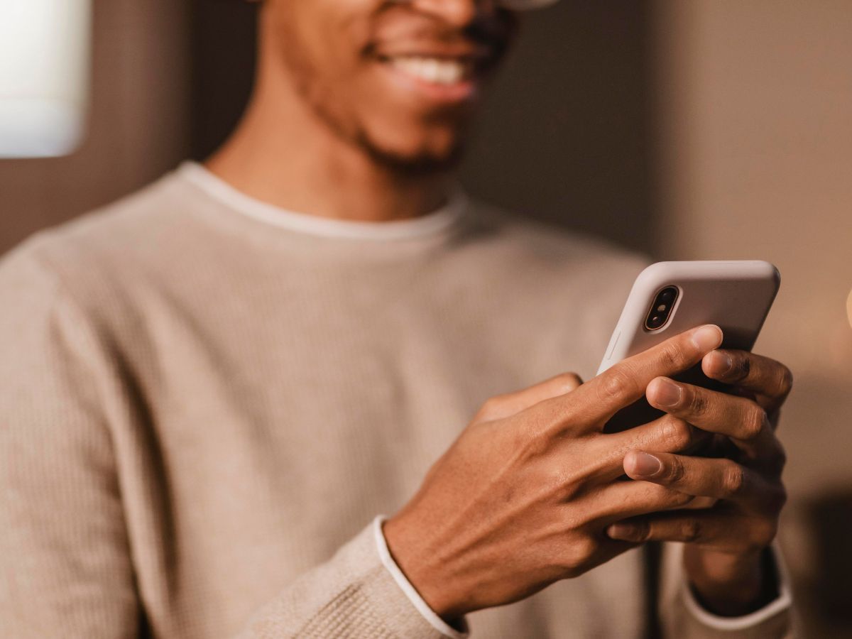 homem sorrindo e usando o celular
