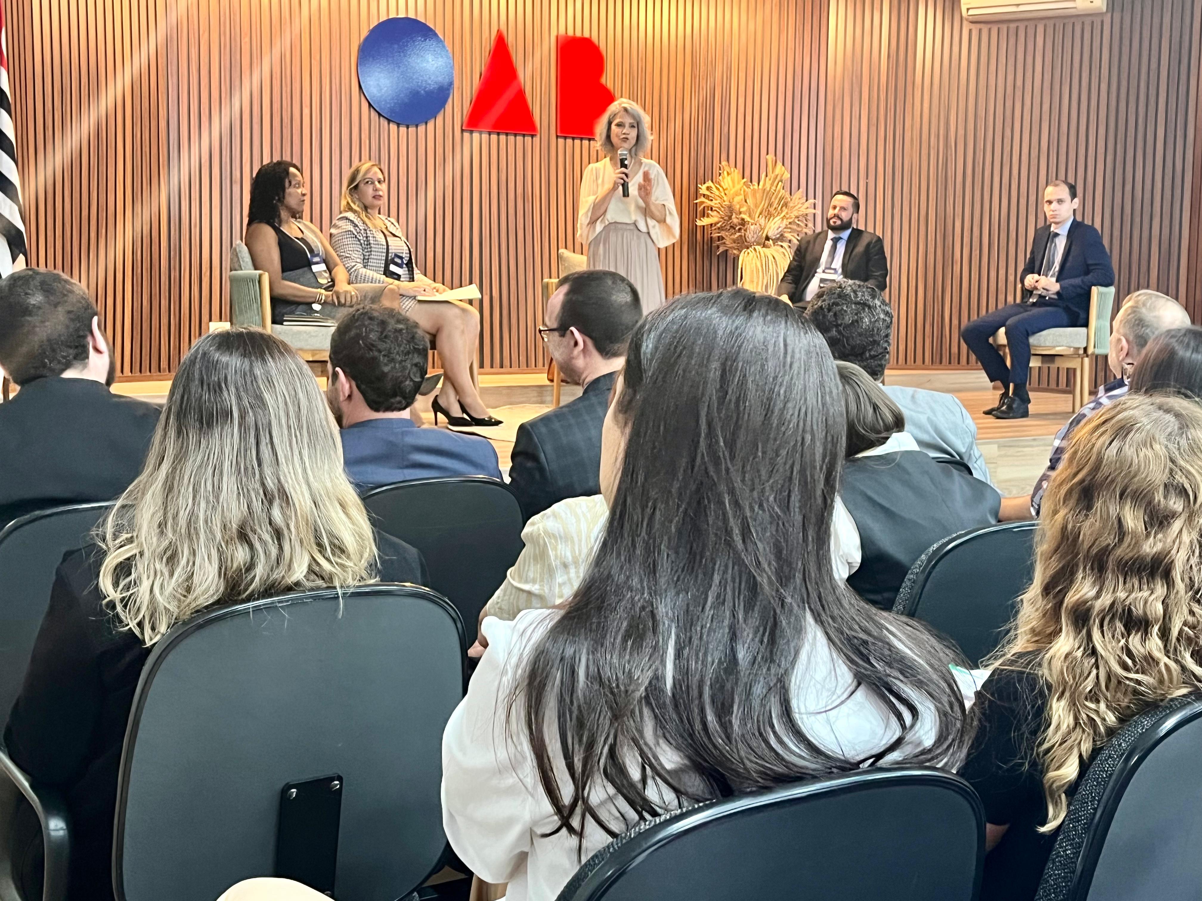 Um grupo de pessoas sentadas em cadeiras em um auditório.